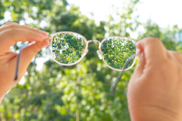 glasses with thin metal frame in female hands,