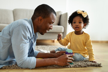 Loving african american dad enjoying game with daughter