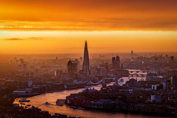 Golden sunset view of the urban skyline of London, England, with River Thames and office skyscrapers
