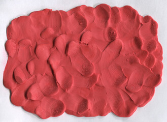 Raw red plasticine texture. Rough playdough textured background. Abstract modelling clay backdrop. Web banner, poster design or label design elements.