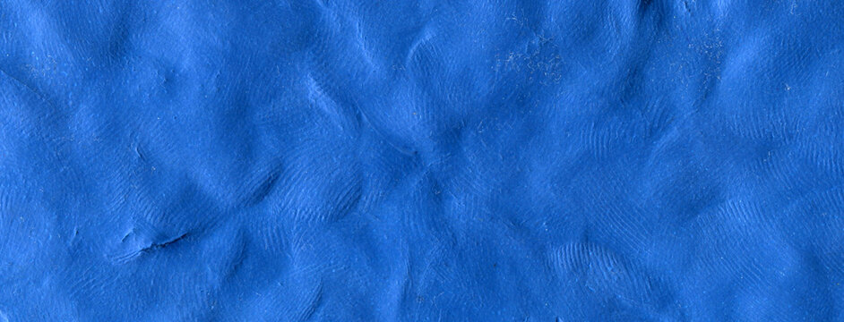 Ultramarine raw plasticine texture. Cobalt blue rough playdough textured background. Abstract modelling clay backdrop. Web banner, poster design or label design elements.