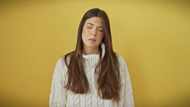 Sleepy young hispanic woman wearing sweater, yawning with lazy eyes, looking bored and exhausted from fatigue and hangover, standing over isolated yellow background, facing morning blues.