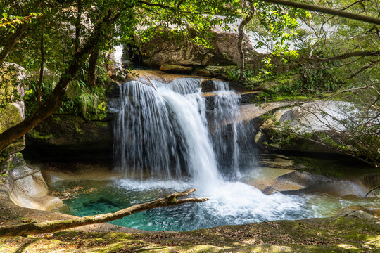 Waterfall cascading into a turquoise pool, creating a serene oasis of natural beauty and tranquility.