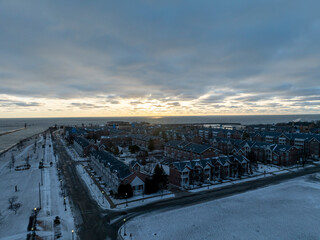 Sunrise over Lake Michigan in Kenosha Wisconsin on a winter morning with a little snow on the ground overlooking several blocks of townhouse apartments