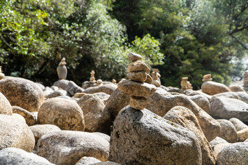 Stacked rocks formed by mountaineers on a rocky beach.