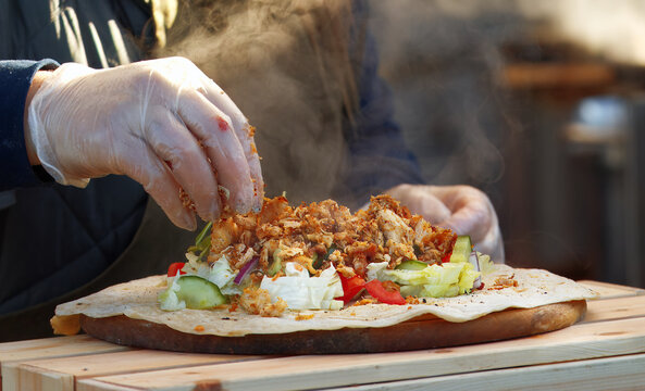 Midsection body of chef making wrap at farmers market stall in Prague Naplavka, Czech Republic.