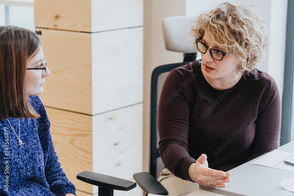 Wall mural Professional women engaged in serious discussion at office table.