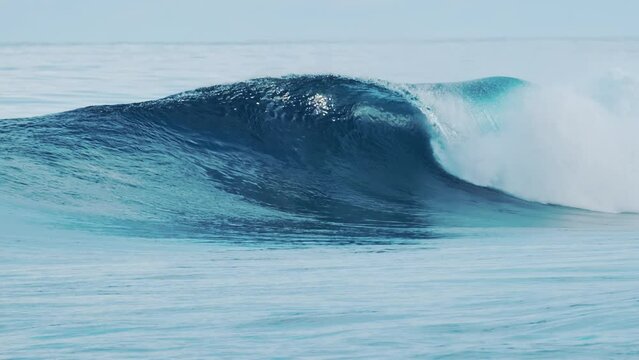 Big glassy ocean wave rolls and breaks in the Maldives