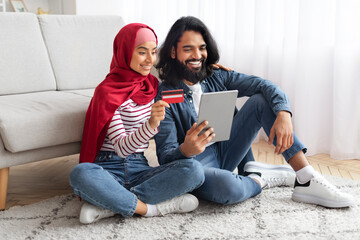 Online Shopping Concept. Happy Muslim Couple Using Digital Tablet And Credit Card