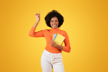 Confident young woman with natural afro hair, wearing an orange top