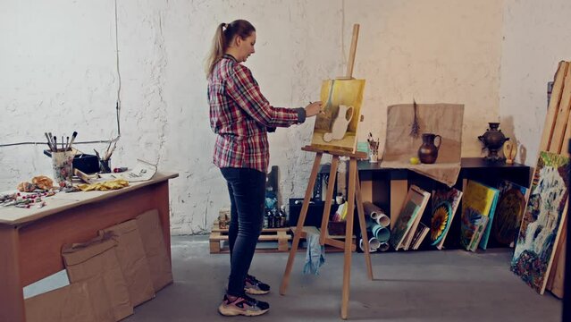 Talented girl artist does an oil painting. Still life painting in warm colors on a canvas. 