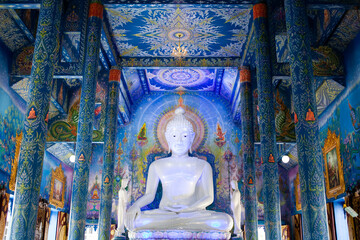buddha statue in blue temple interior in Chiang Rai