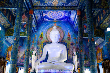 buddha statue in blue temple interior in Chiang Rai