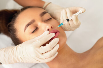 Beauty injection. Millennial woman making lip augmentation procedure