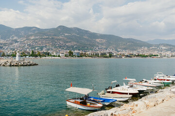 Fototapeta na wymiar Boats docked on calm waters with a scenic town backdrop under a clear sky