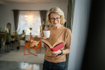 One woman mature caucasian female read book at home wear eyeglasses