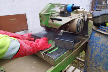 Robotnik, cięcie kostki brukowej piłą do betonu. © Stanisław Błachowicz