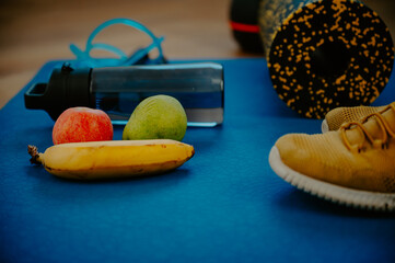 Oranges, granola bars, and a jump rope laid out on the exercise mat. Quick snacks to power up your fitness regimen