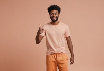 Cheerful man in a peach tee giving a thumbs up, his casual look and upbeat attitude radiate positivity.