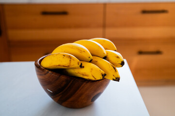 A sunlit kitchen moment: banana placed on the table - 747595779