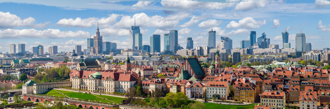 Warsaw old town and distant city center, PKiN and skyline under blue cloudy sky aerial landscape