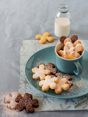 Selection of homemade shortbread cookies sprinkled with powdered sugar, arranged in a blue cup with...