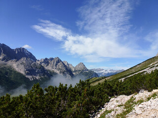 A beautiful mountain landscape of rocky mountain slopes on which stones are scattered and grass...