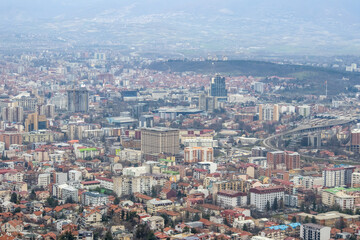 Fototapeta na wymiar European mountain city seen from above at sunset on a cloudy day, Skopje the capital city.