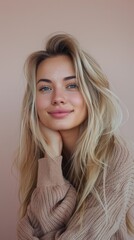 Fototapeta premium A young woman with long, groomed blonde hair wearing a cozy sweater smiles at the camera.