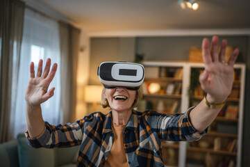 Woman mature senior female at home enjoy virtual reality VR headset
