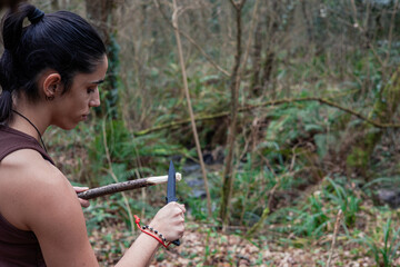 closeup explorer girl cutting wood with his knife