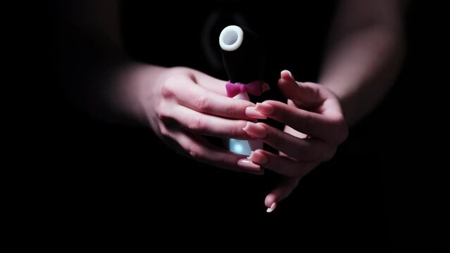 Vibrator in the shape of a penguin. Vacuum-wave clitoral stimulator in the hand of a girl on a black background. Sex Shop Products, Adult Gifts for Couples, Adult Store
