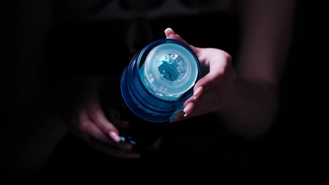 Sex toys for men. Male automatic telescopic masturbator in the hands of a girl on a black background. Male massager. Sex shop Adult store, toys for two
