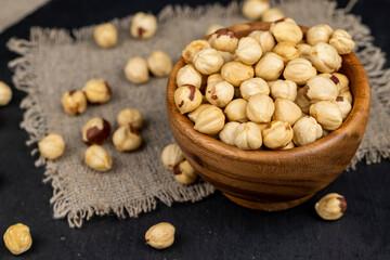 peeled roasted hazelnuts in a wooden bowl, close-up