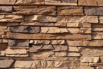 Fragment of brown flat stone wall