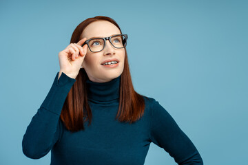 Confident attractive woman wearing stylish glasses looking away standing isolated