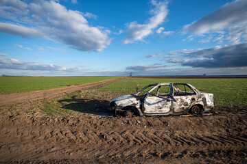 A burned out car. Burnt car in the field. Car fire, vehicle fire due to short circuit. Stolen car...