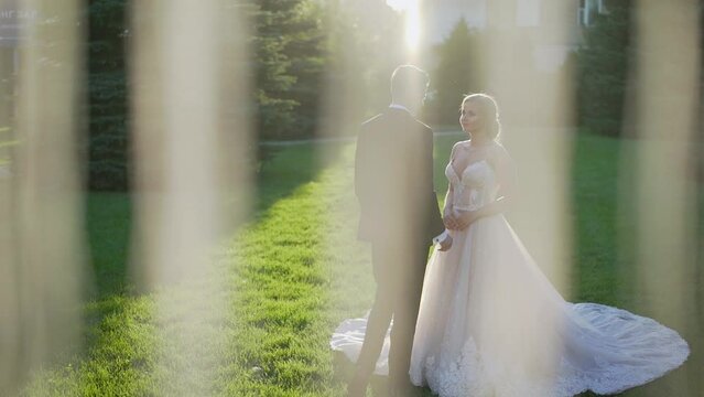 Look over groom's shoulder at happy crying bride. The bride sees the groom for the first time on their wedding day. The bride looks at the groom and cries.