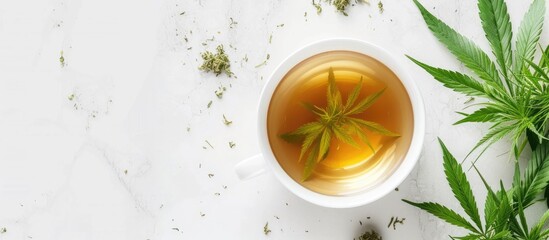 A cup of hemp tea with a marijuana leaf floating in it, placed on a white marble floor. The image captures the combination of cannabis and tea in a simple yet intriguing composition. - obrazy, fototapety, plakaty