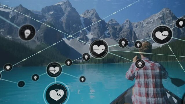 Animation of network of connections with icons over caucasian man in boat on lake in mountains