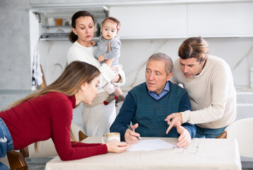 People of different generations argue with each other and show an elderly father how to fill out documents correctly
