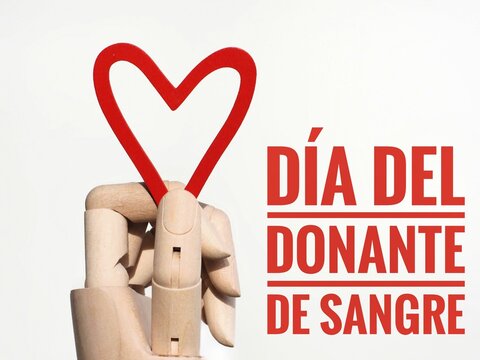 Blood donor day concept. Poster with red spanish text D&iacute;a del donante de sangre and hand holding a heart