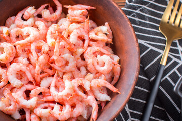 Boiled peeled shrimp with soy sauce on a plate. Dietary seafood