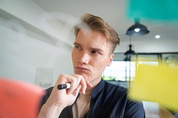 Professional caucasian businessman brainstorming marketing idea by using mind map and sticky notes...