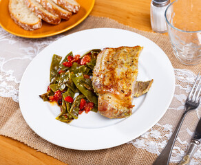 Dish of pork ribs with stewed green beans closeup