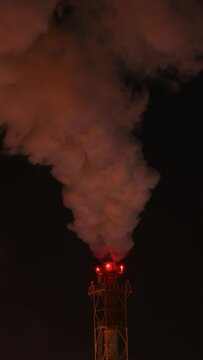 Refinery chimney at low temperature. Close-up. Night scene