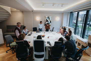Fototapeta na wymiar Collaborative team brainstorming ideas at a spacious conference table in a bright, contemporary office setting, showcasing teamwork and communication.