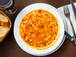 Asturian fabada soup with white beans and blood sausage served in bowl