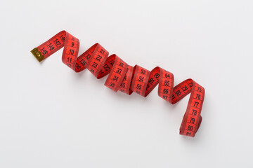 Measuring tape on color background, top, view