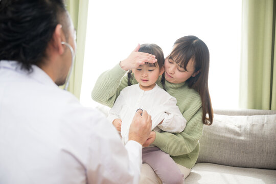 発熱で子供を診察する医師(ドクター）　訪問診療やクリニックなどの病院のイメージ